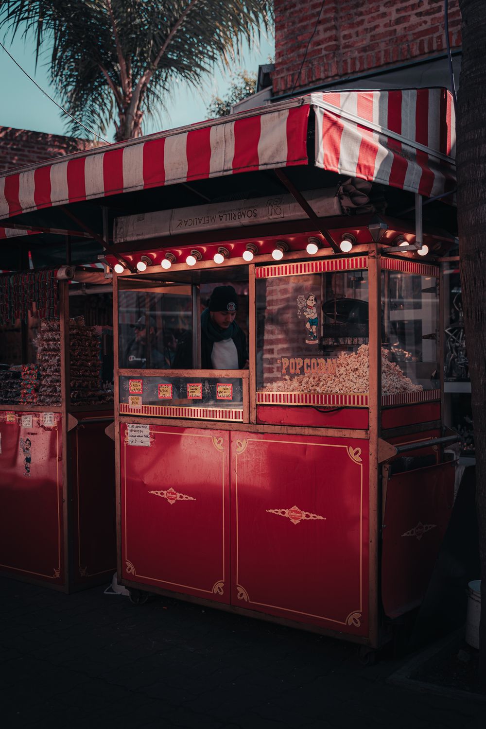 A popcorn cart glowing in the evening at a celebration